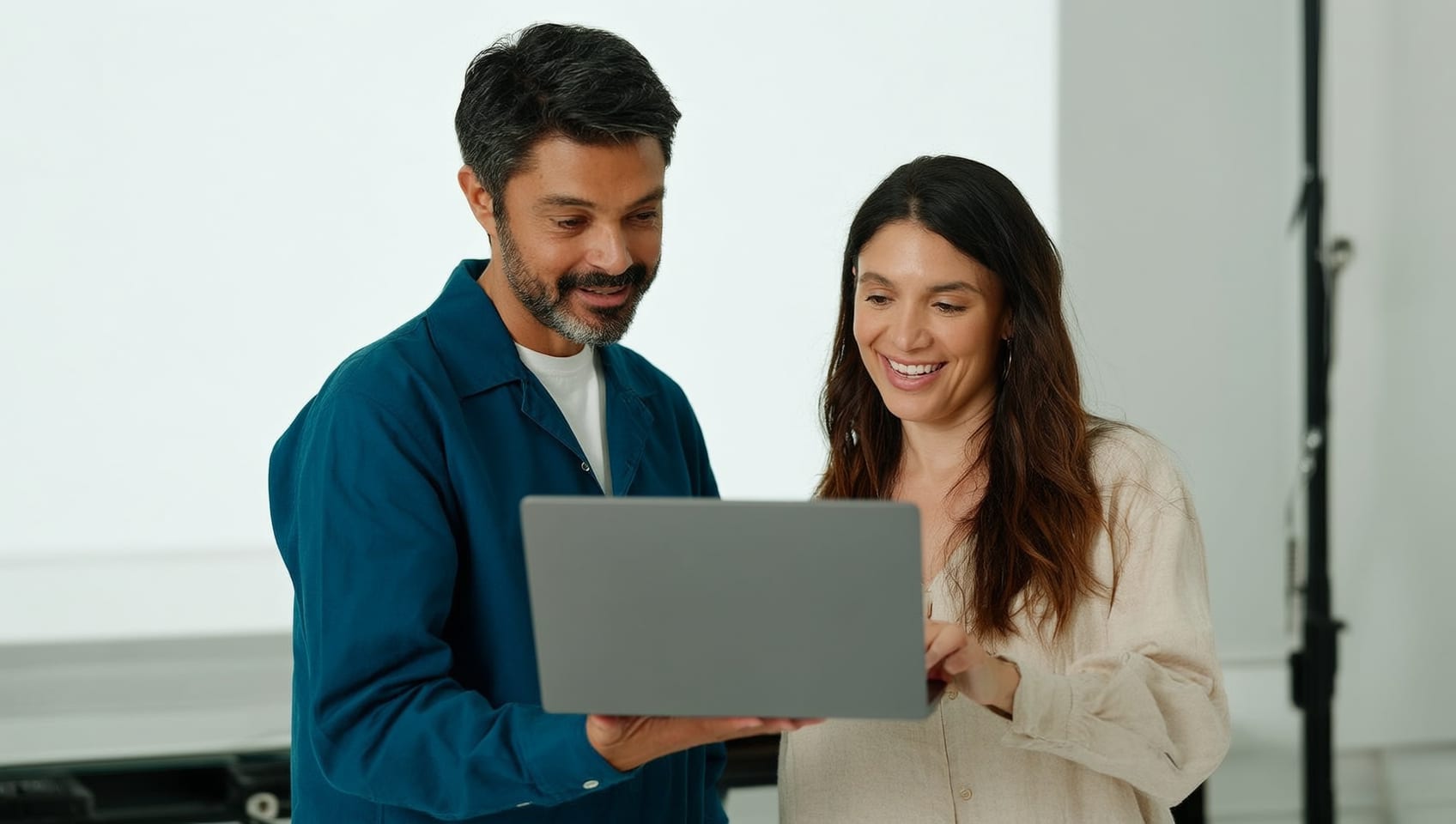 A JulyWork engineer and a managing broker reviewing the platform together in a bright studio office
