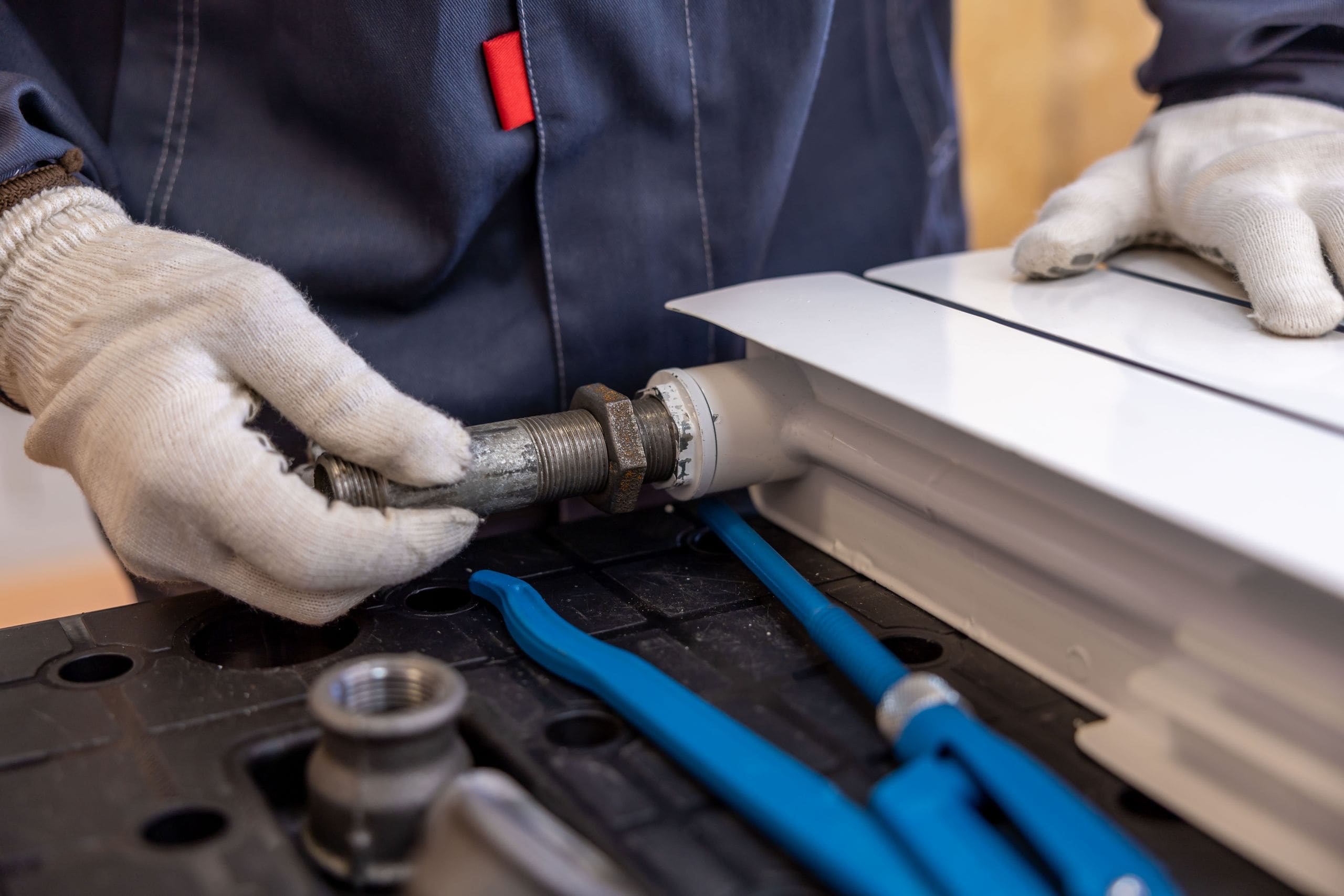 A plumber installing a radiator pipe fitting