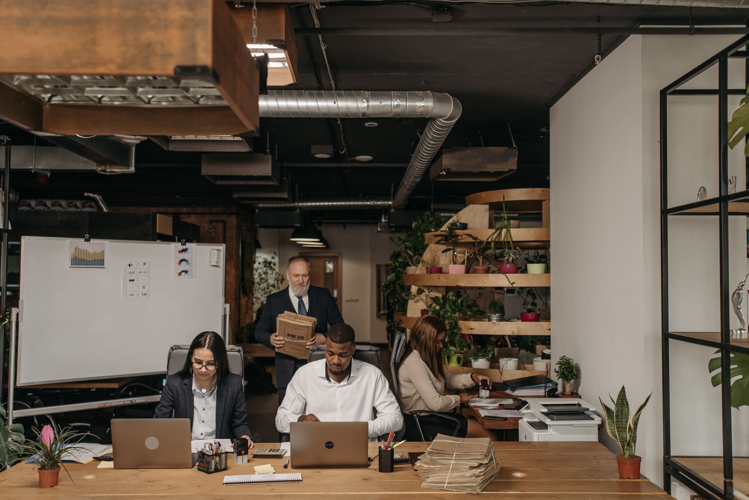 A small office team at work on their laptops in a loft workspace